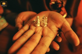 In Kaifeng, Henan, China, the mother holds up her hands, proudly displaying a pair of golden dragon and phoenix wedding rings for the camera.
